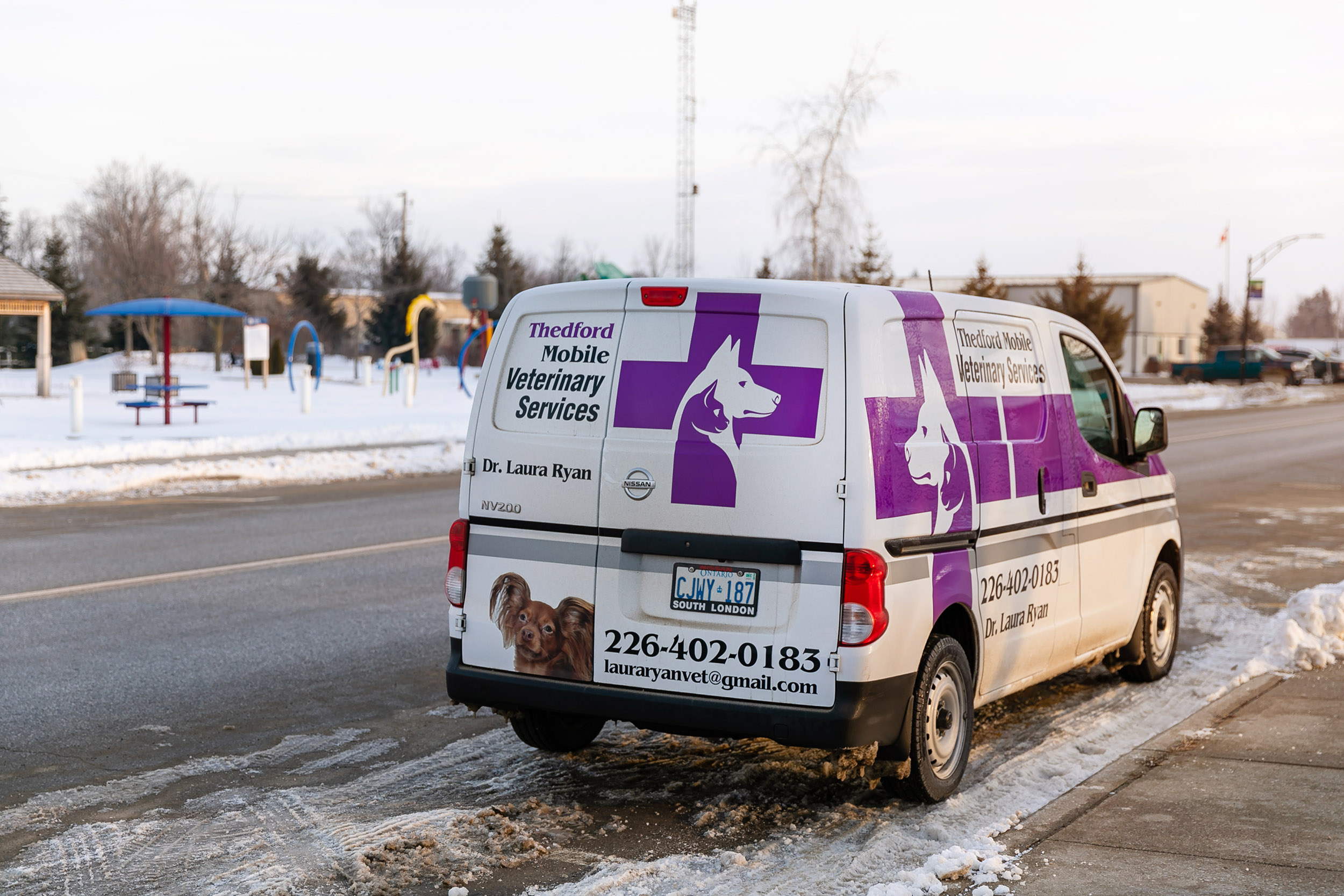 Rear of the clinic van, with a photo of Czar, a Russian Toy Terrier, on the back door
